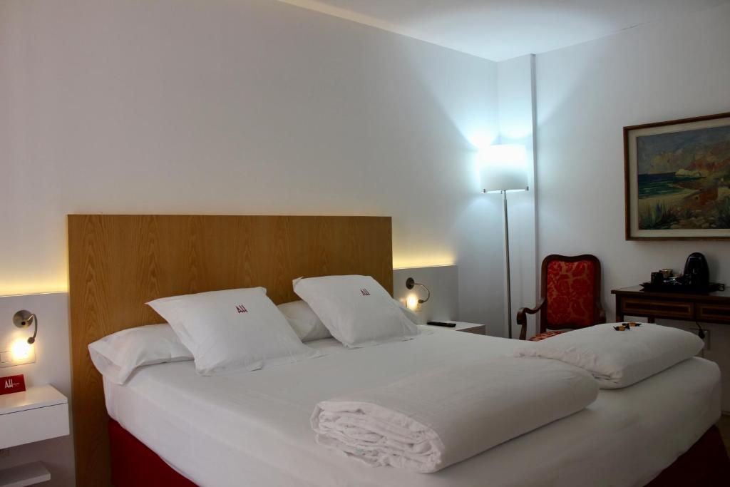 a bedroom with a large white bed with white pillows at AH Art Hotel Palma in Palma de Mallorca
