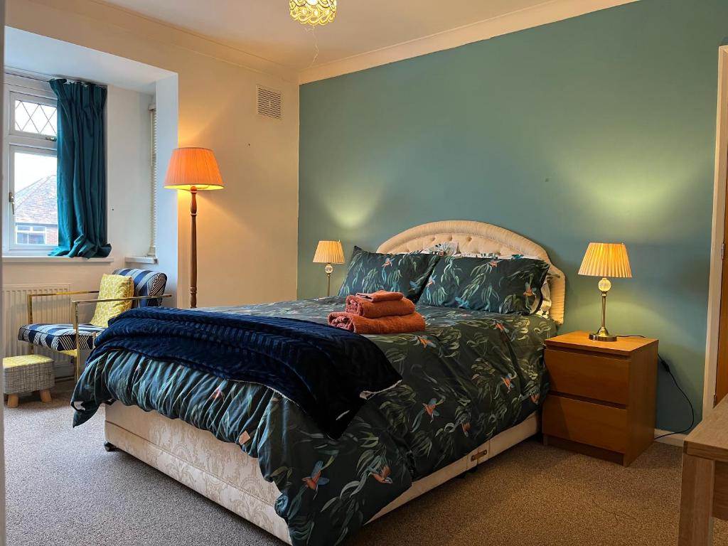 a bedroom with a large bed with blue walls at Westfield Cottage in Cottingham