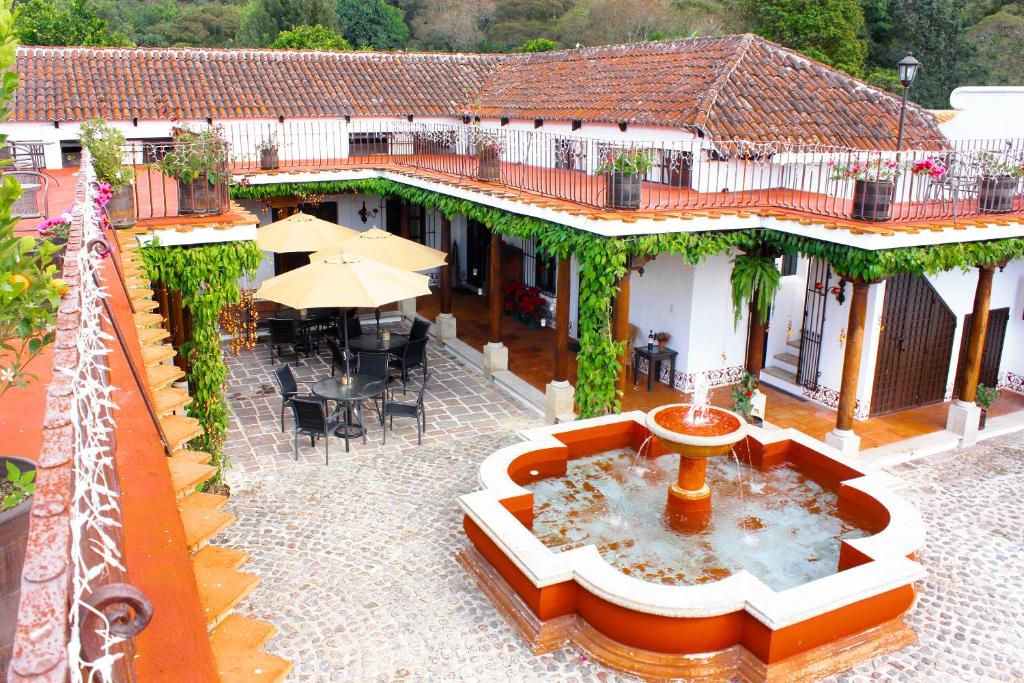 a building with a fountain in the middle of a courtyard at Villas de la Ermita in Antigua Guatemala