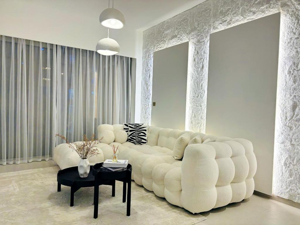 a living room with a large white couch and a table at Luxury 1BR Apt Best view Infinity Pool Burj Khalifa with Balcony in Dubai