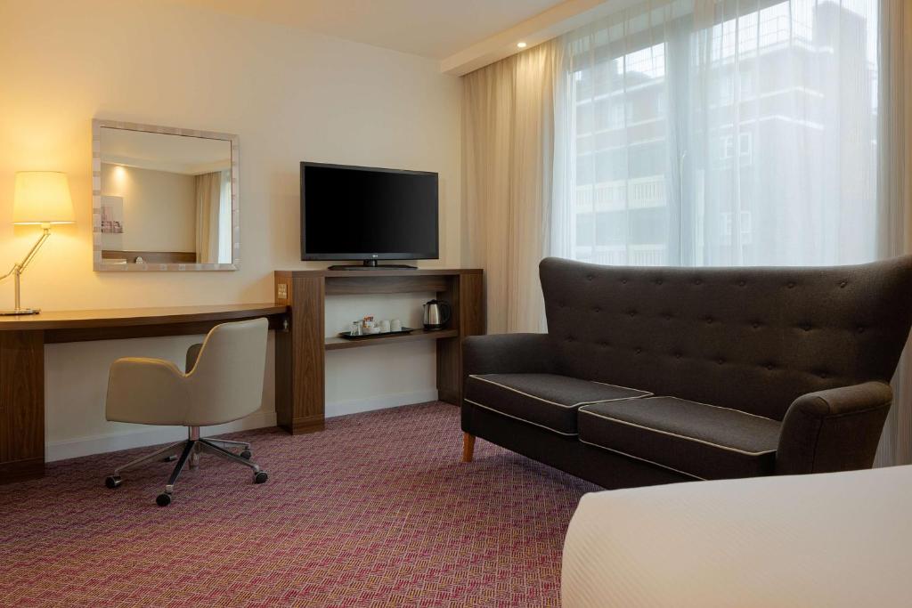a hotel room with a couch and a television at Hampton by Hilton London Waterloo in London