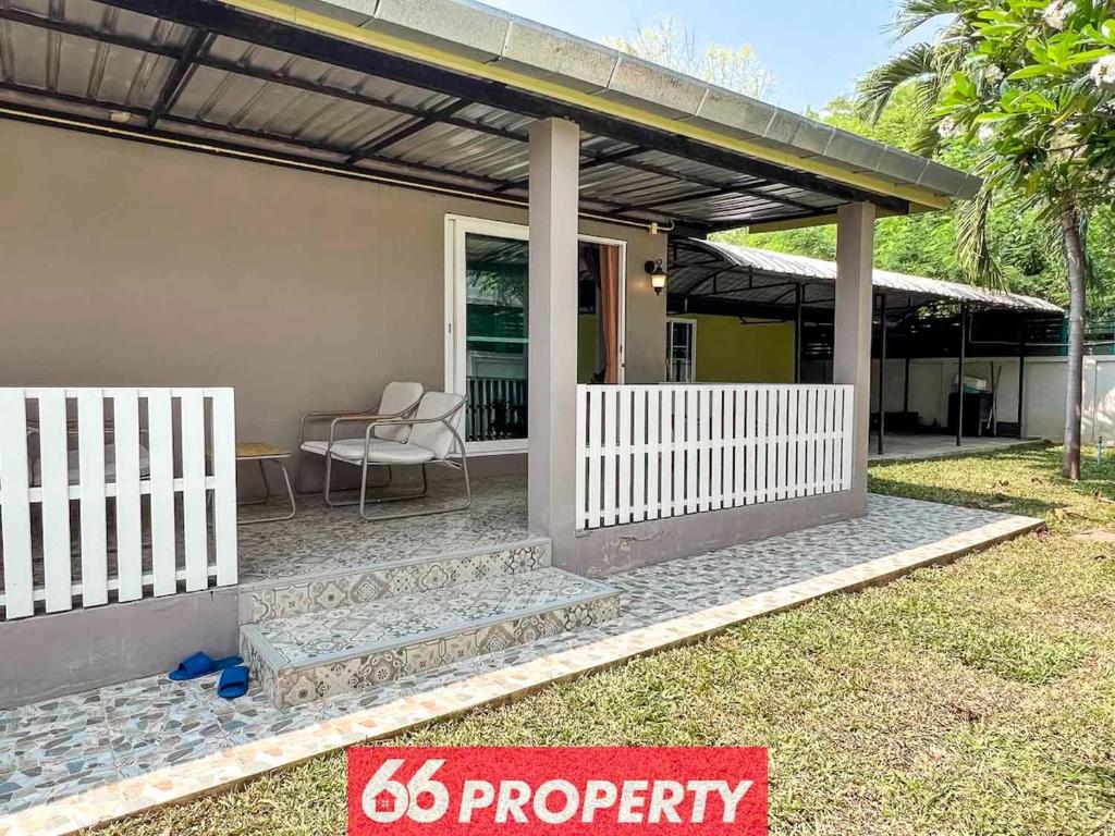 a house with a white fence and a patio at Nimman Home with Cozy Patio - Workspace w Screen in Chiang Mai