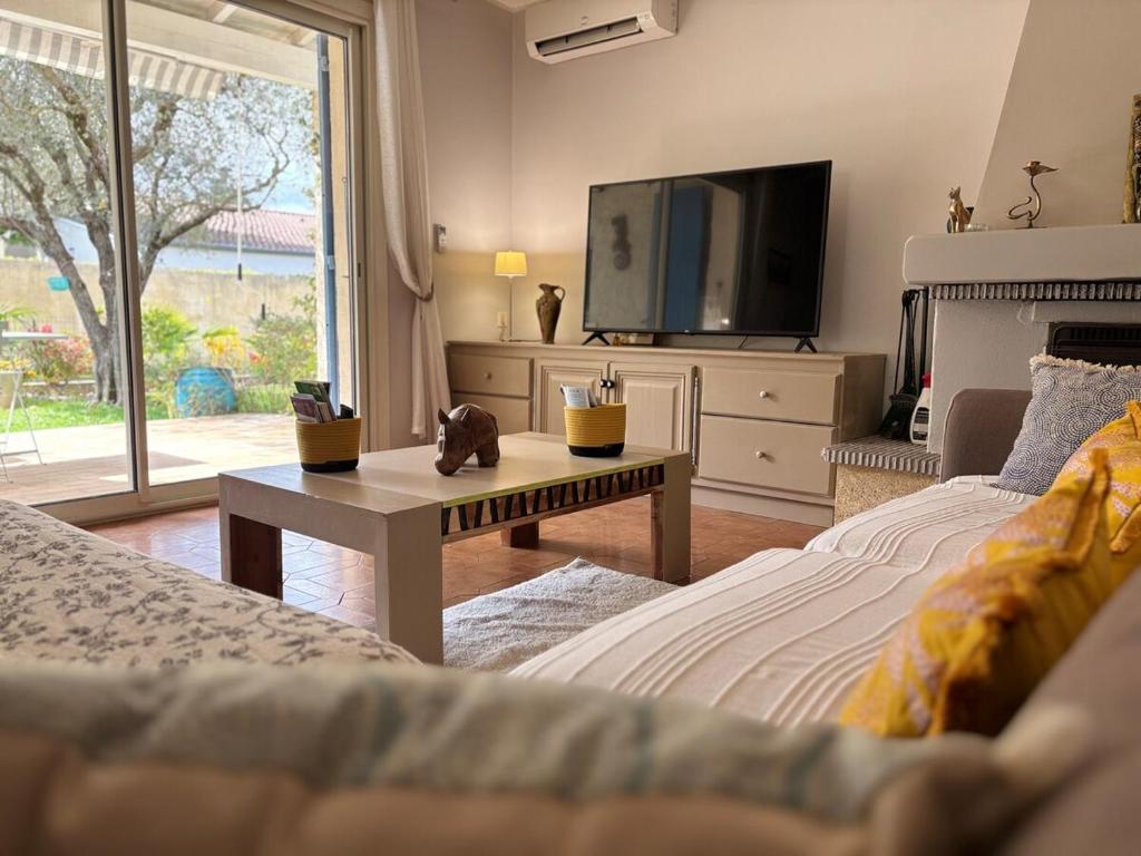 - un salon avec 2 lits et une télévision dans l'établissement Le Clos de Val, à Valréas