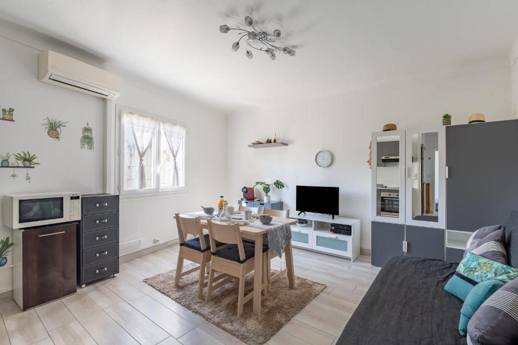 un salon avec une table et une cuisine dans l'établissement Appartement moderne au coeur de Cannes, à Cannes