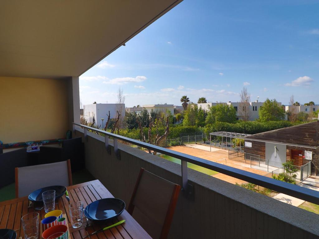 d'un balcon avec une table et une vue sur un court de tennis. dans l'établissement Sète : Appt 2 Pièces, Climatisé, Résidence avec Piscine - FR-1-472-210, à Sète
