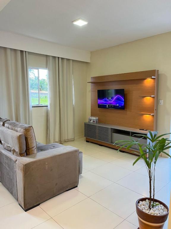 a living room with a couch and a flat screen tv at Casa de praia Duplex com Piscina Flecheiras in Trairi