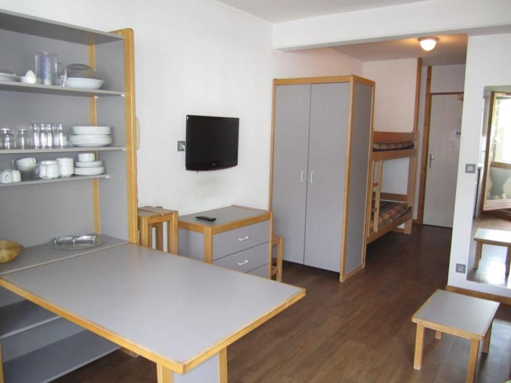 eine Küche mit einem Tisch und einem TV in einem Zimmer in der Unterkunft Studio Centre Brides-les-Bains avec WIFI et Parking - FR-1-512-132 in Brides-les-Bains