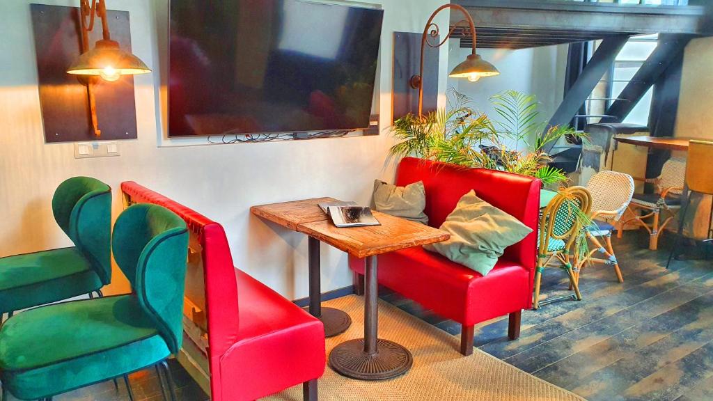 a restaurant with red chairs and a wooden table at Loft Zen Rouen - Jacuzzi - Centre Historique in Rouen