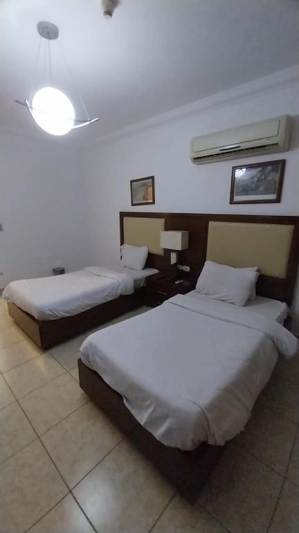 a hotel room with two beds and a light at شاليه في منتجع دلتا شرم ريزورت in Sharm El Sheikh