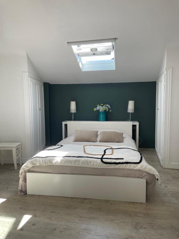 une chambre avec un lit blanc avec un mur bleu dans l'établissement 1er secret de Honfleur, à Honfleur