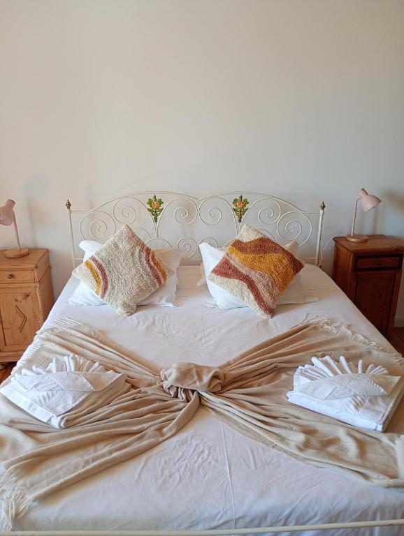 a bed with white sheets and pillows on it at Casa da Talha By Viva a Vida - Alojamentos & Hotels in Constância