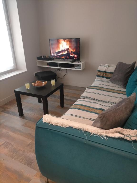 un salon avec un canapé et une télévision à écran plat dans l'établissement S Bourgeois 2 Charmant T3 tout équipé au centre, à Sedan