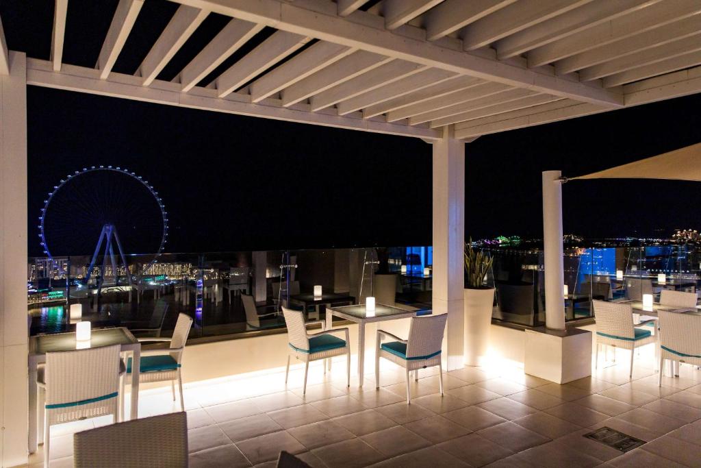 a restaurant with a view of the city at night at Hilton Dubai The Walk in Dubai