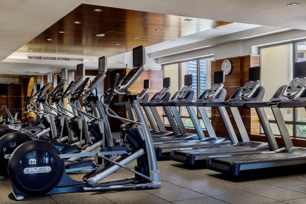 a gym with a row of treadmills and machines at Hilton Dubai The Walk in Dubai