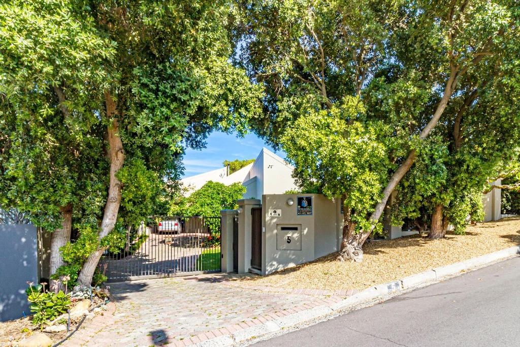 een gebouw met een boog midden tussen de bomen bij 5 on Paul Kruger in Somerset West