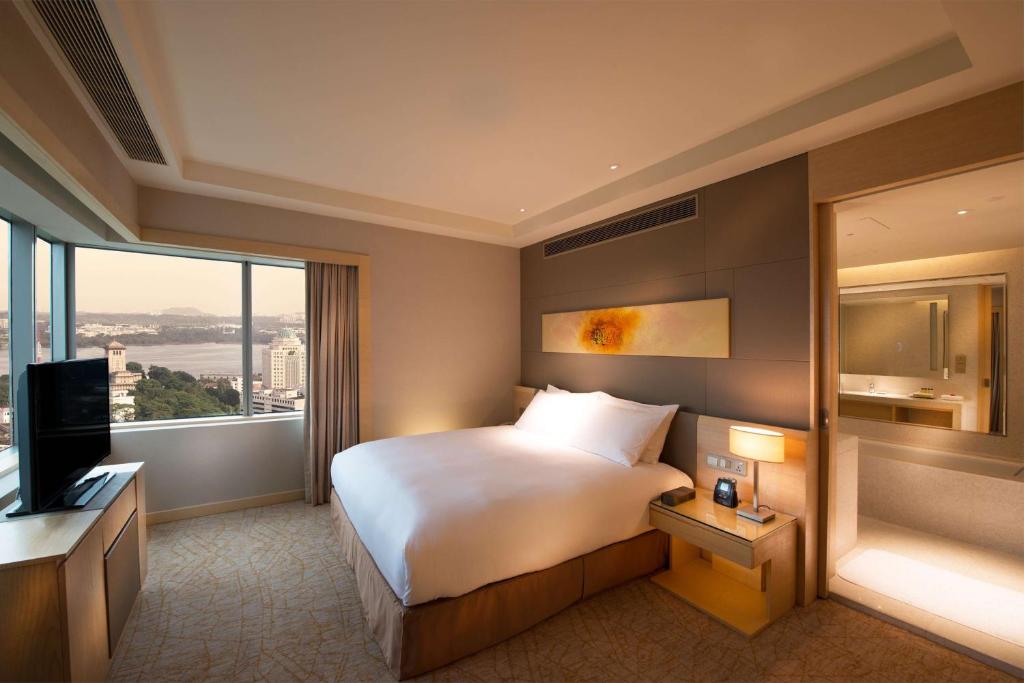 a hotel room with a bed and a large window at DoubleTree by Hilton Johor Bahru in Johor Bahru