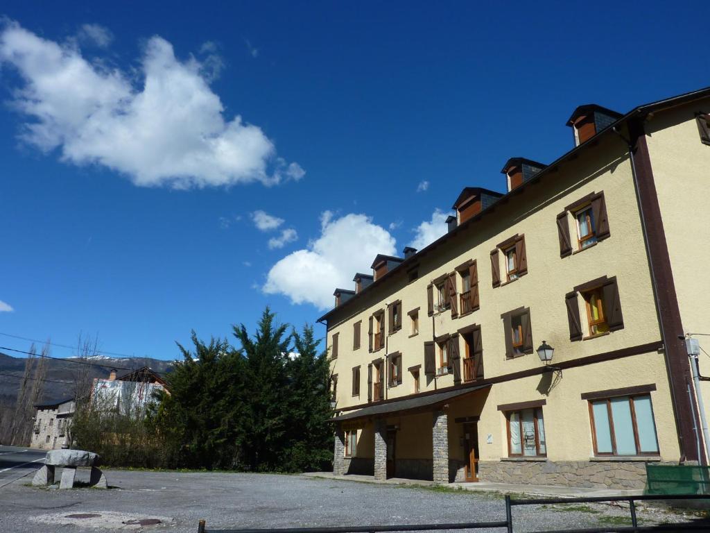 un gran edificio amarillo con un cielo azul en el fondo en El Molino, en Castejón de Sos