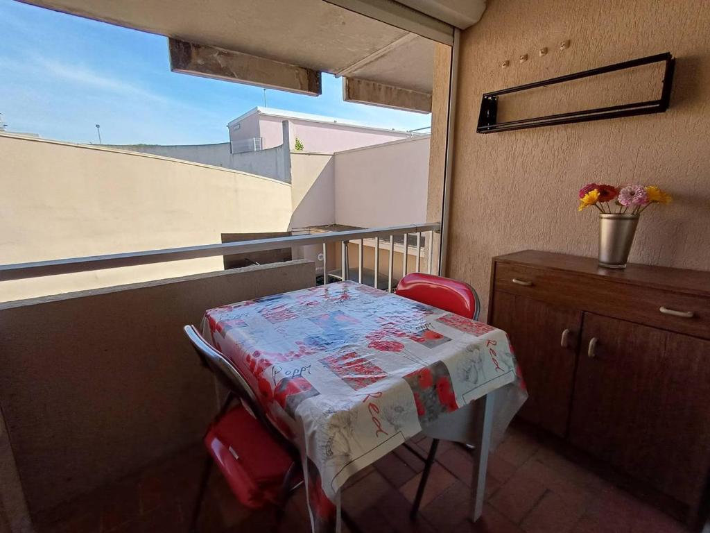 une table et des chaises dans une pièce avec une fenêtre dans l'établissement T1 agréable avec parking privé, proche étang de Thau, climatisé, cuisine équipée, loggia, Balaruc-les-Bains - FR-1-571-33, à Balaruc-les-Bains