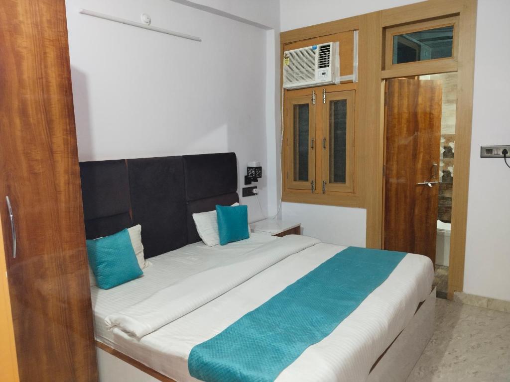 a bedroom with a large bed with blue pillows at Golden Bar And Hotel in Sandīla