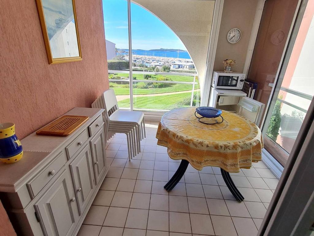 une cuisine avec une table et une table et une fenêtre dans l'établissement T3 avec Piscine - Tennis - Parking - À 200m des plages/commerces - FR-1-316-294, à Six-Fours-les-Plages