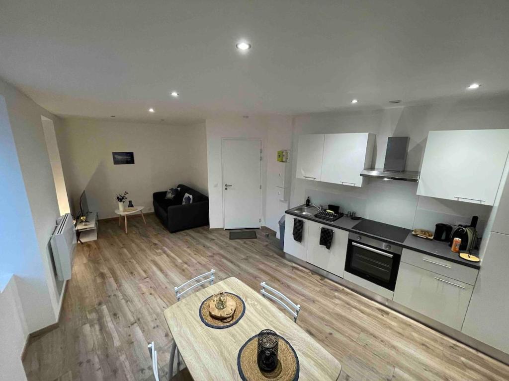 un salon avec une table et une cuisine dans l'établissement Apparement au centre de Semur en Auxois, à Semur-en-Auxois