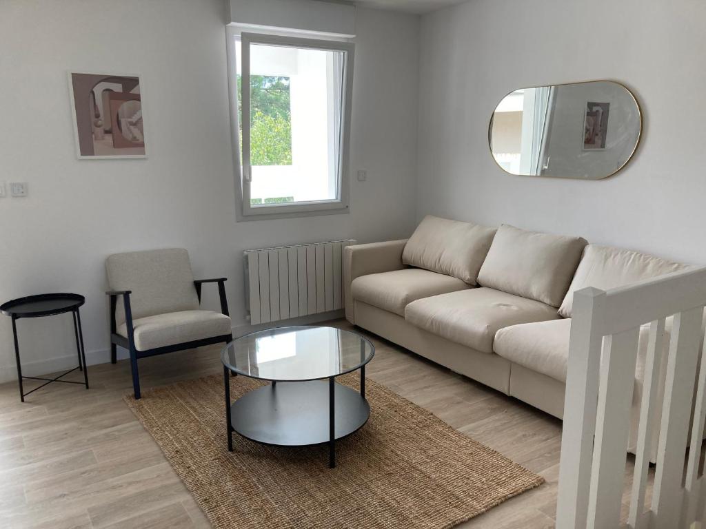 un salon avec un canapé, une table et une chaise dans l'établissement Gare et vieux port, à La Rochelle