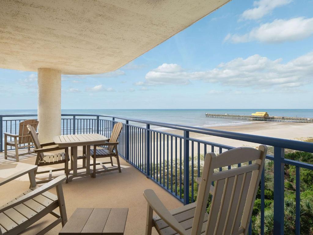 a balcony with chairs and tables and a view of the beach at Kingston Plantation Condos in Myrtle Beach