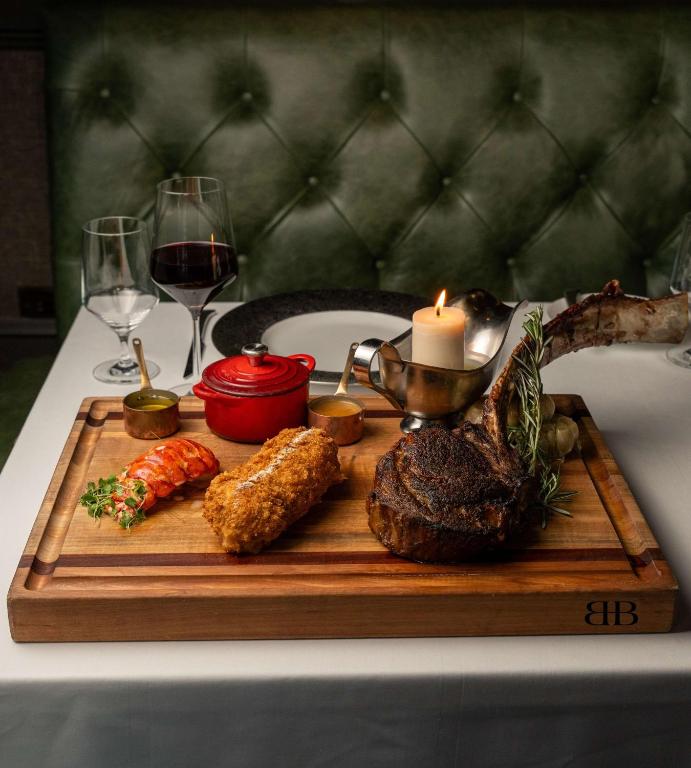 a cutting board with meat and vegetables and a candle at Waldorf Astoria Orlando - An Official Walt Disney World Hotel in Orlando