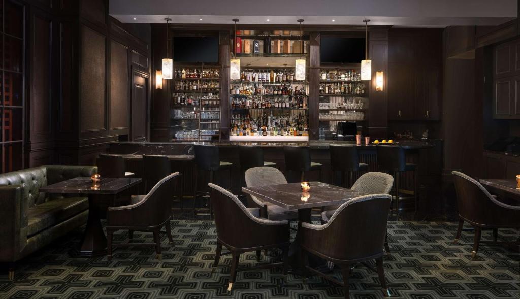 a restaurant with tables and chairs and a bar at Waldorf Astoria Orlando - An Official Walt Disney World Hotel in Orlando