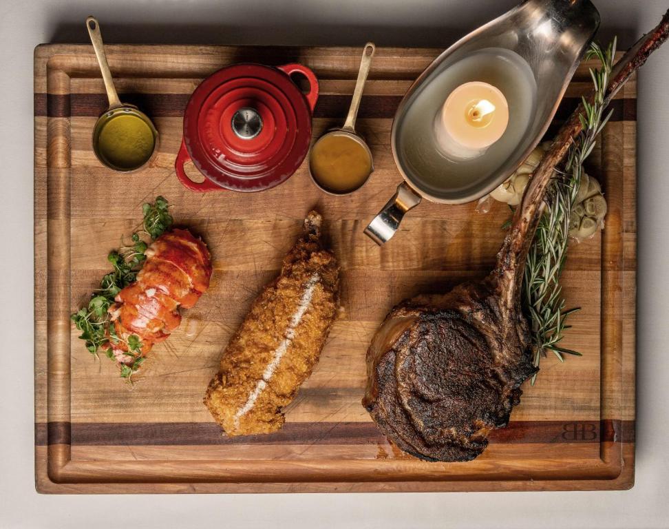 a cutting board with a steak and different types of food at Waldorf Astoria Orlando - An Official Walt Disney World Hotel in Orlando