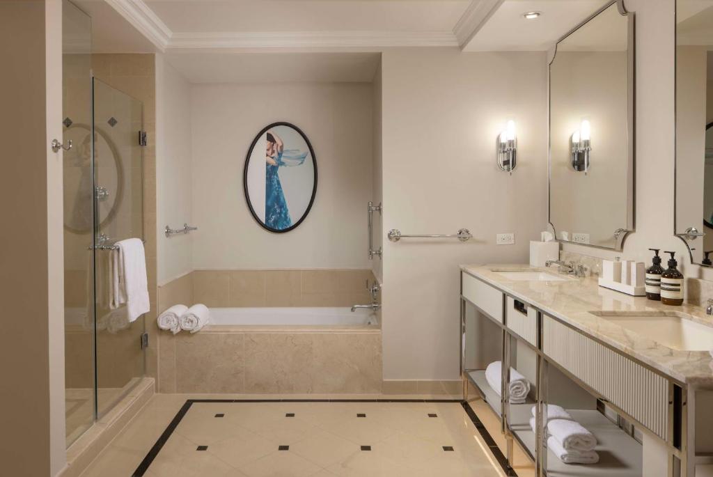 a bathroom with a shower and a sink and a tub at Waldorf Astoria Orlando - An Official Walt Disney World Hotel in Orlando