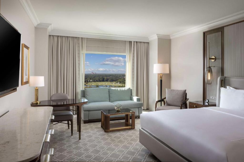 a hotel room with a bed and a living room at Waldorf Astoria Orlando - An Official Walt Disney World Hotel in Orlando