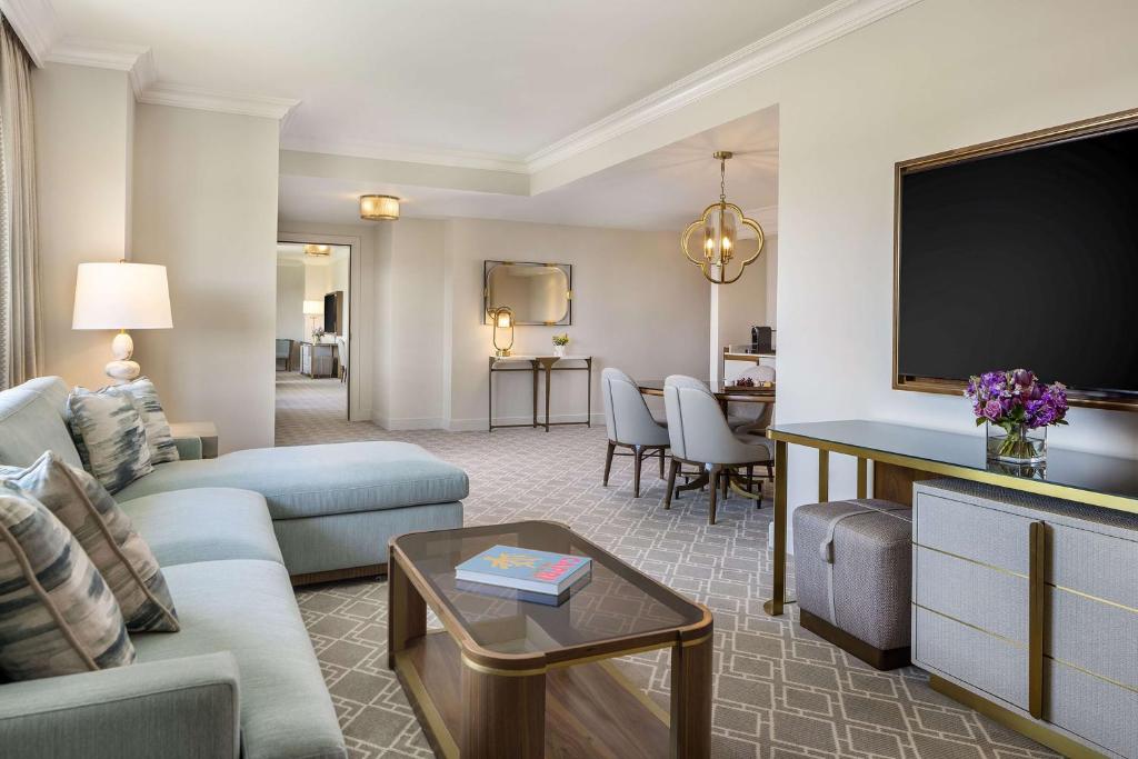 a living room with a couch and a flat screen tv at Waldorf Astoria Orlando - An Official Walt Disney World Hotel in Orlando