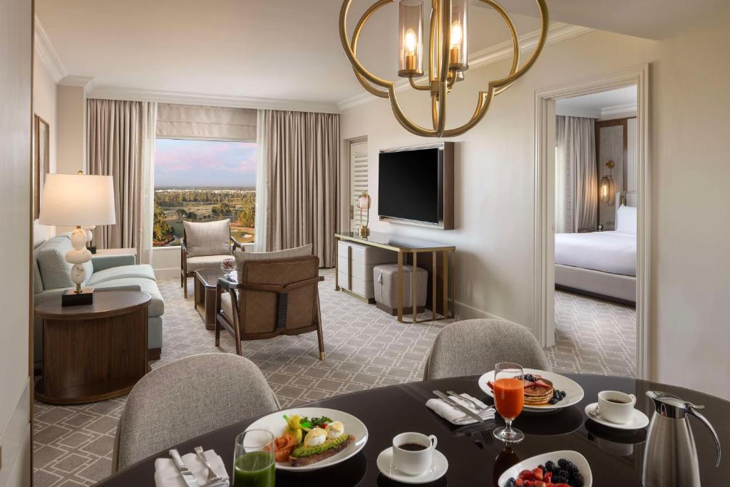 a hotel room with a dining table and a living room at Waldorf Astoria Orlando - An Official Walt Disney World Hotel in Orlando
