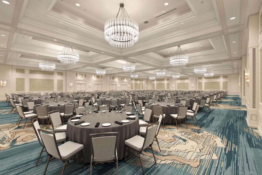 a large banquet hall with tables and chairs and chandeliers at Waldorf Astoria Orlando - An Official Walt Disney World Hotel in Orlando