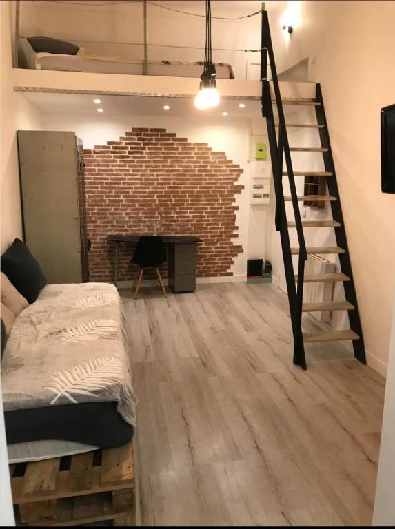 une chambre avec un lit et un mur de briques dans l'établissement Loft cosy centre ville, à Nice