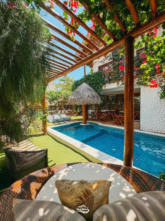a swimming pool with a table and an umbrella at Pousada Vila Bella Icaraí in Icaraí