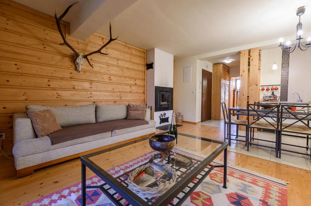 a living room with a couch and a table at Apartament W Dolinie Słońca & SPA in Kościelisko