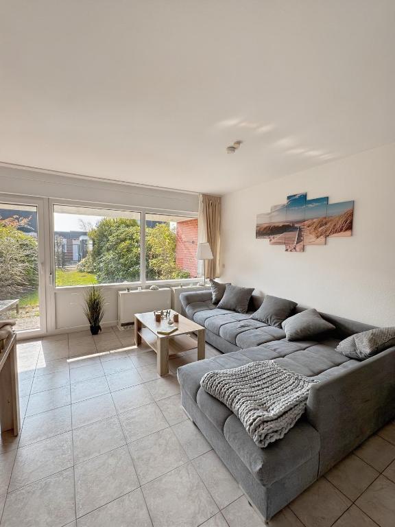 a living room with a couch and a table at Deich&Düne Nordsee -Apartment in Schillig