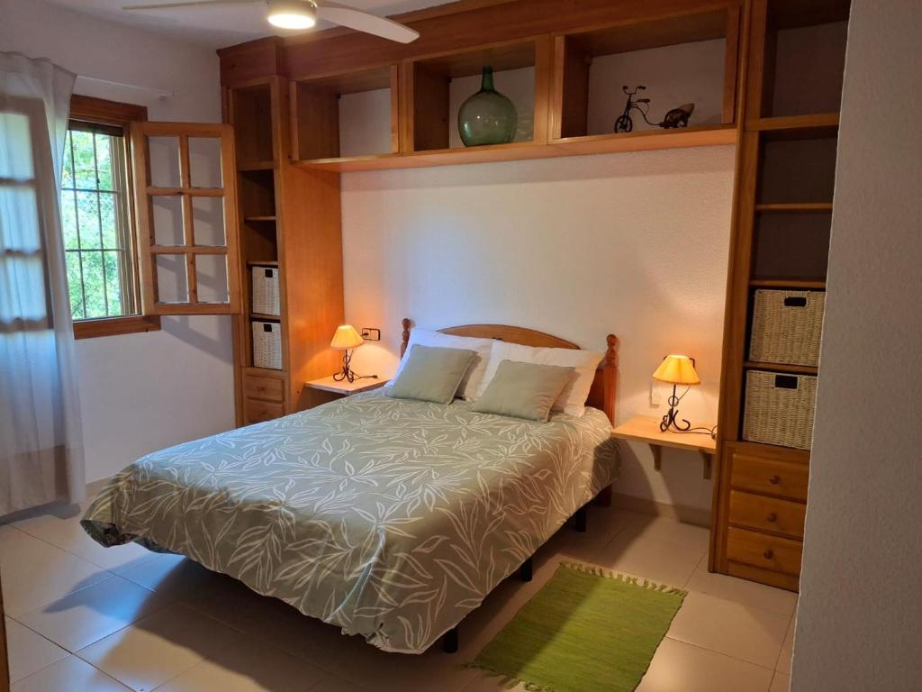 Un dormitorio con una cama y dos mesas y dos lámparas. en Apartamento Calablanca con amplia terraza y vistas al mar y a la montaña, en Alcossebre