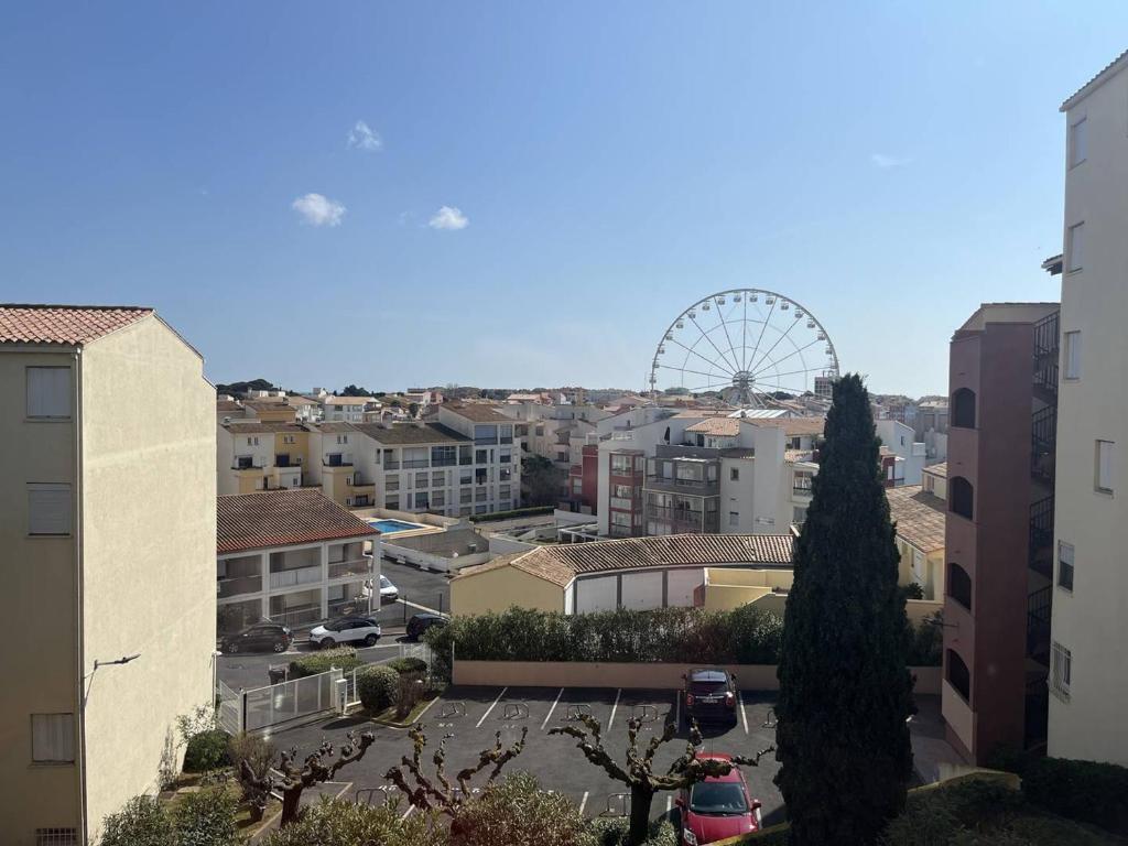 une vue sur une ville avec une roue ferris en arrière-plan dans l'établissement Studio Cabine Centre Port pour 4 avec Parking et Animaux admis - FR-1-749-92, au Cap d'Agde