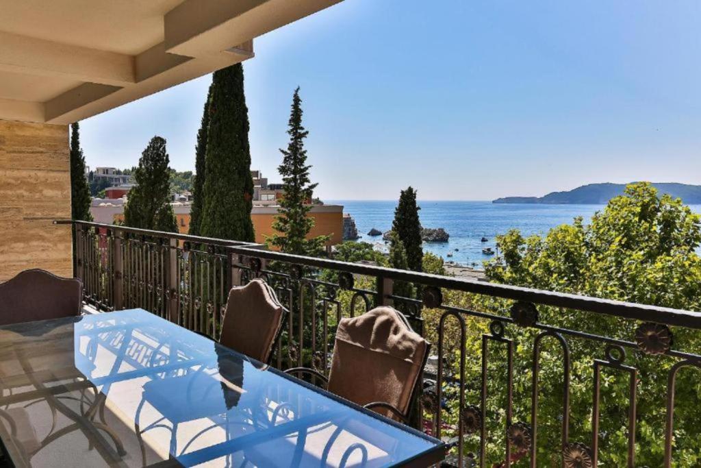 a balcony with a table and chairs and the ocean at Luxury Apartments Przno in Budva