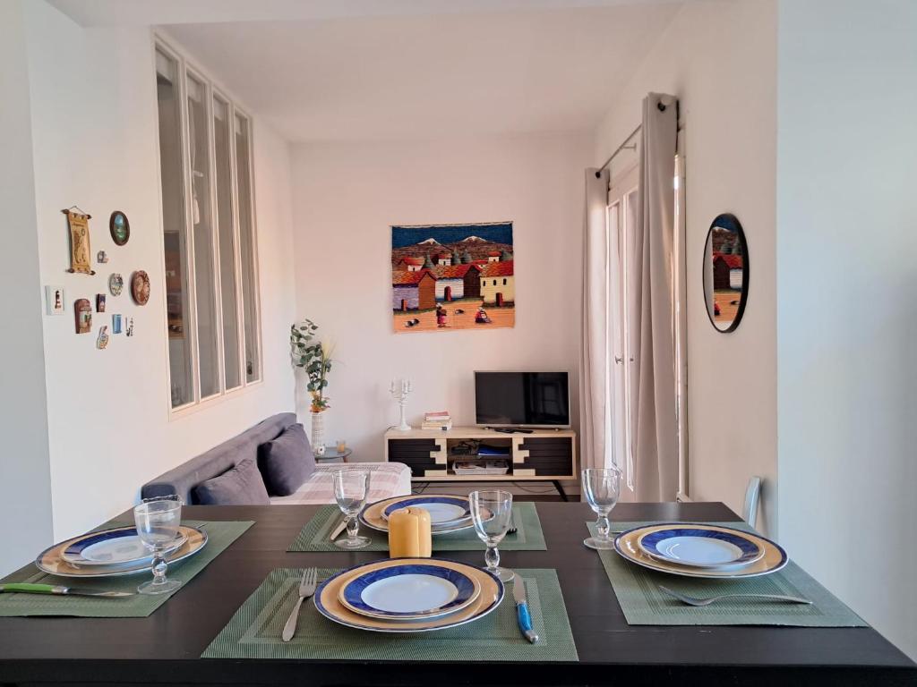 - une salle à manger avec une table et des assiettes dans l'établissement F2 Cozy near City Center and Train Station, à Perpignan