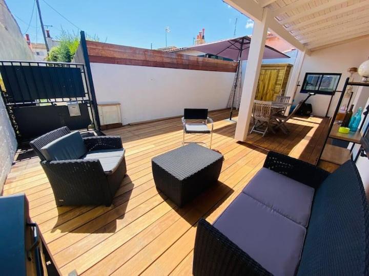 d'un balcon avec un canapé et des chaises sur une terrasse. dans l'établissement La Maréchale, à La Rochelle