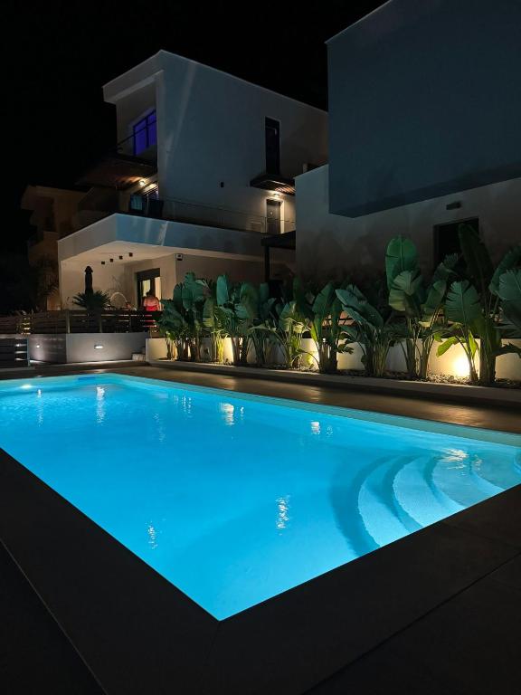 a swimming pool at night in front of a house at Kyan Executive Suites in Iraklitsa