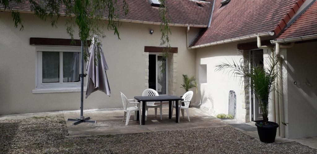 a table and chairs in front of a house at Le petit gîte de Beauval in Mareuil-sur-Cher