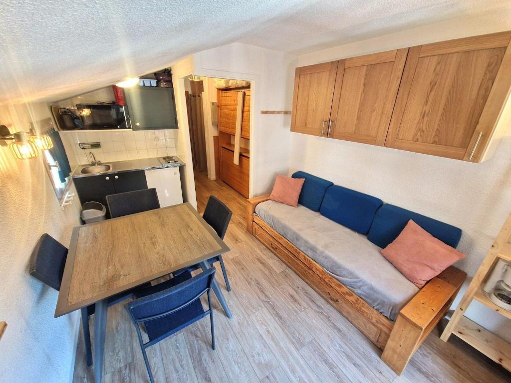 un salon avec un canapé bleu et une table dans l'établissement Studio pour 4 personnes avec balcon, à 2 pas des pistes et commerces, cœur de station, Modane - FR-1-265-224, à Valfréjus