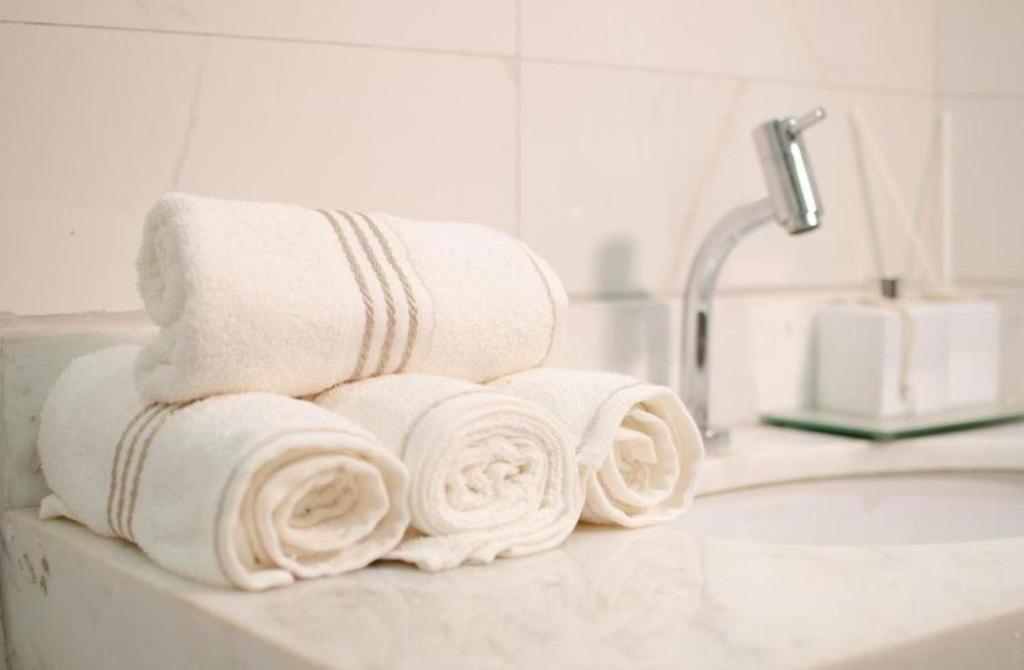 a pile of towels sitting on top of a bathroom sink at William santos Garcia in Natal