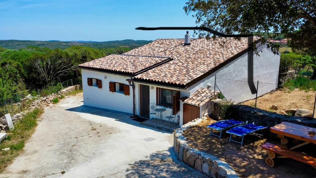 a small white house with a table and chairs at Cottage Vittoria in Marazzino