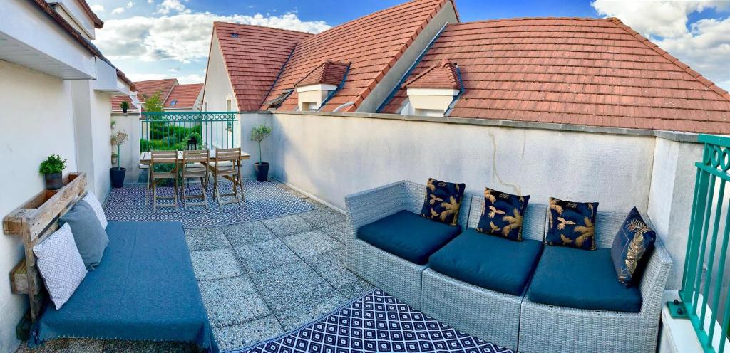 d'une terrasse avec un canapé et une table sur un balcon. dans l'établissement Mickey M'house Familly, à Magny-le-Hongre
